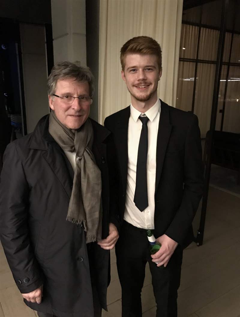 一位年輕人站在米歇爾·帕瑪強(qiáng)尼 (Michel Parmigiani) 旁邊。